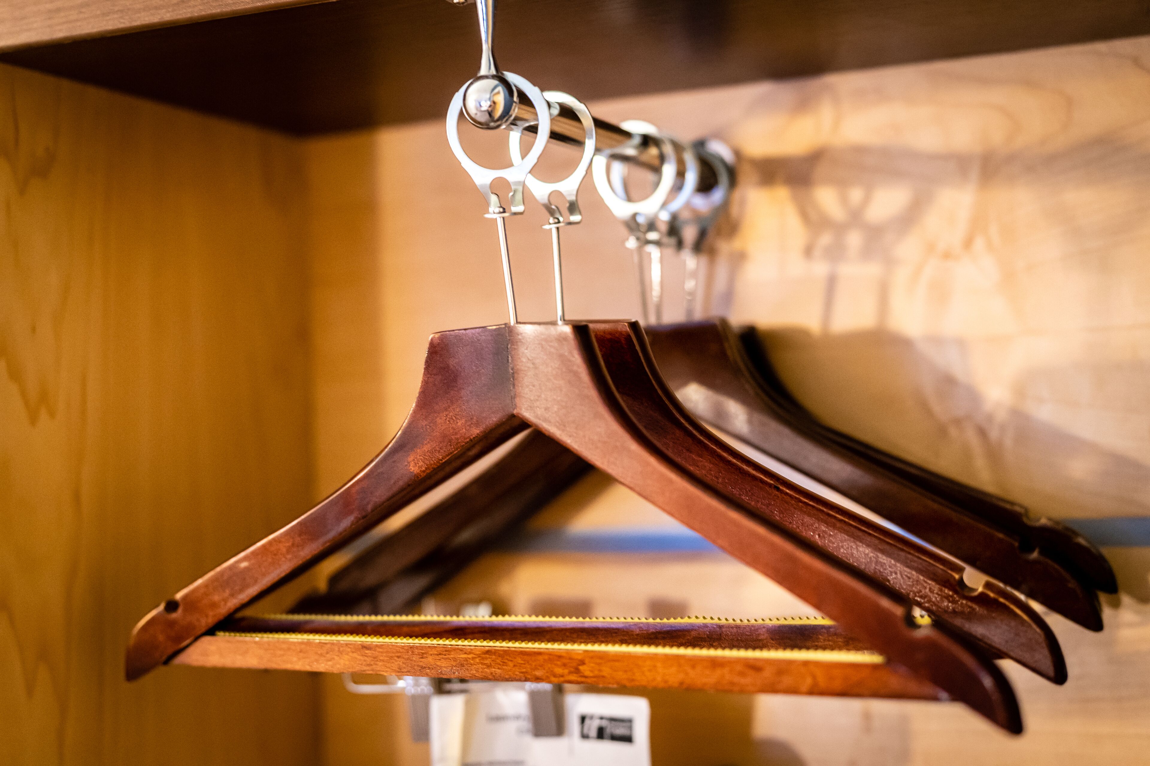 A wooden hanger rack with multiple hangers.