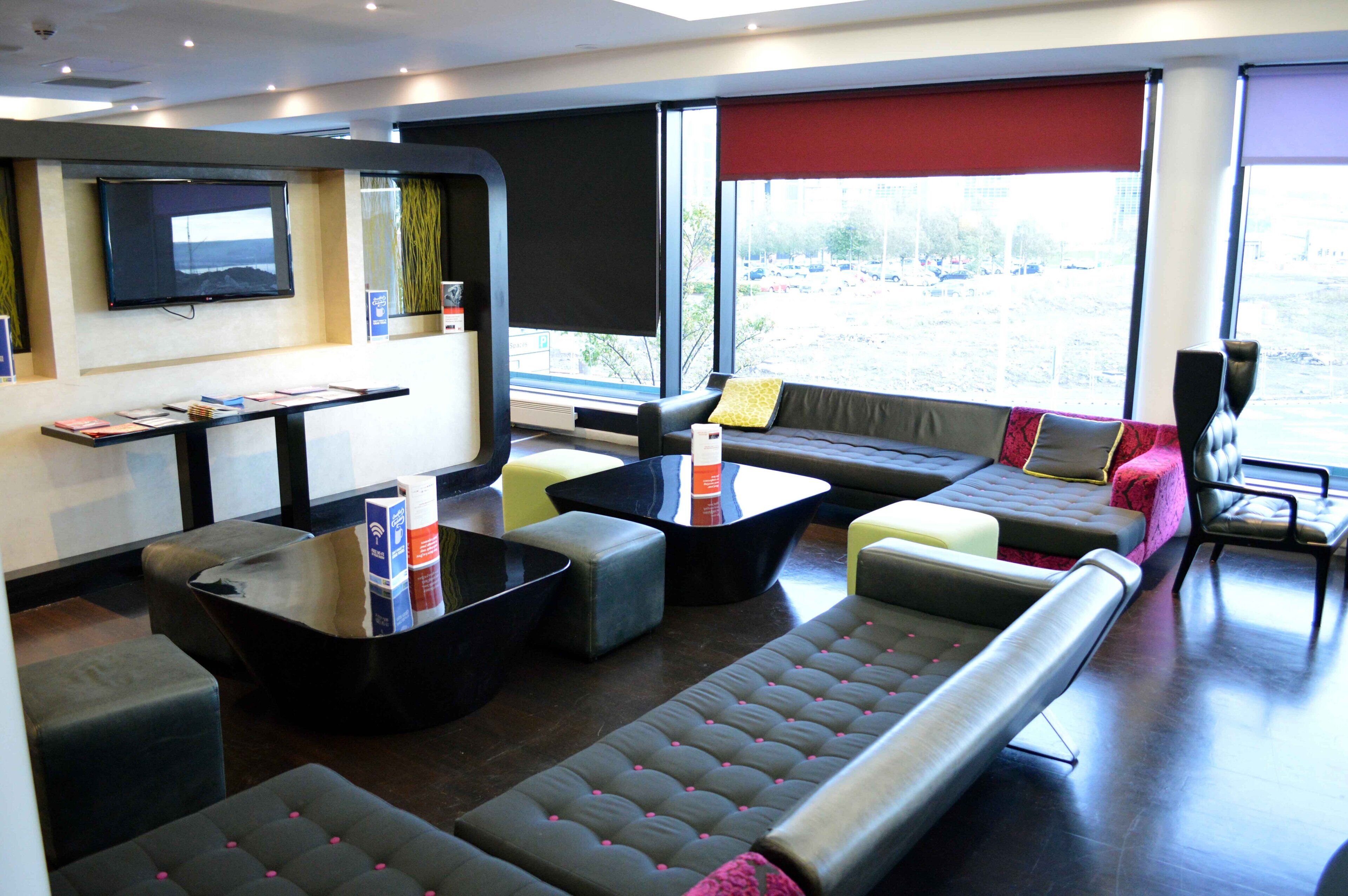 A modern lounge area with a sofa, ottomans, and a coffee table.
