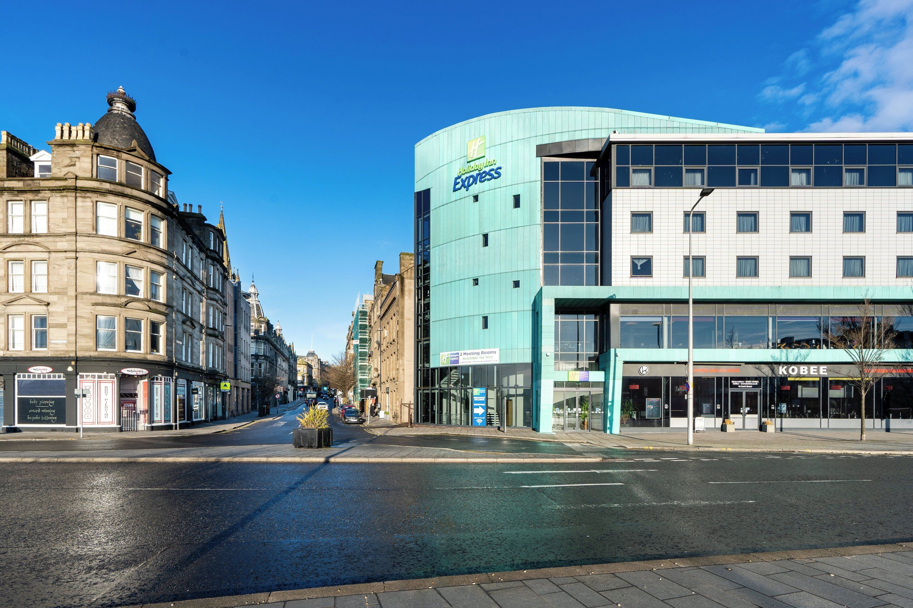 A hotel with a modern design, featuring a large glass facade and signage for 'Holiday Inn Express'.