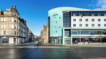 A hotel with a modern design, featuring a large glass facade and signage for 'Holiday Inn Express'.