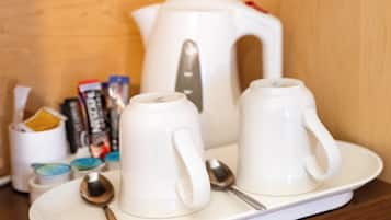 Un plateau sur lequel se trouvent deux tasses blanches, une théière blanche et deux cuillères.