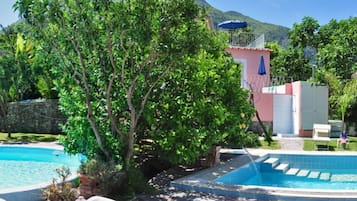 Una piscina cubierta, una piscina al aire libre de temporada, sombrillas