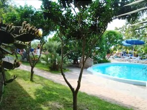 Una piscina cubierta, una piscina al aire libre de temporada, sombrillas