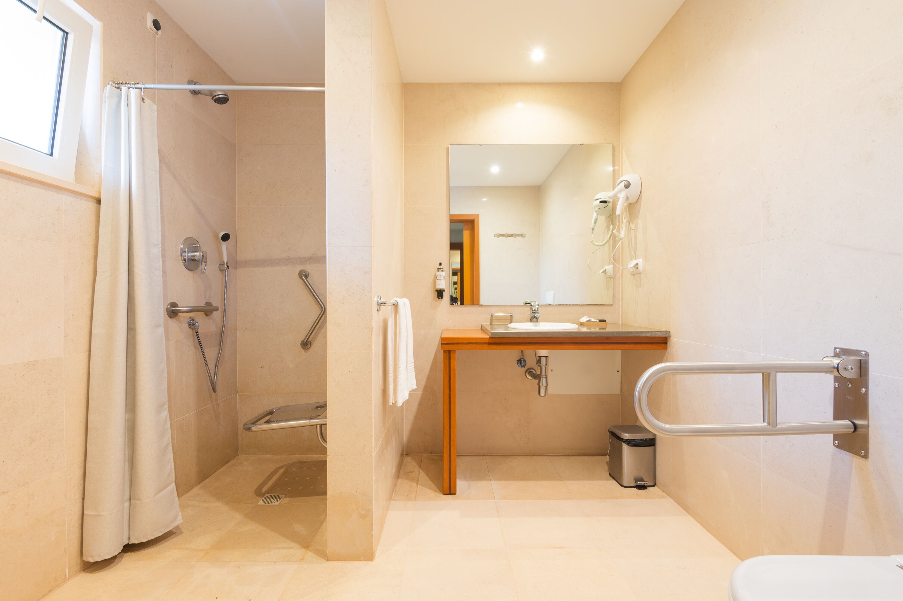 Een moderne badkamer met douche, toilet en wastafel.