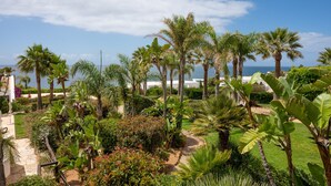 A tropical garden with palm trees and a view of the ocean. - Vila Luz (Lagos)