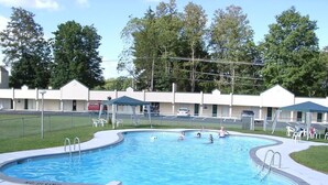 A swimming pool with a 'NO DIVING' sign, surrounded by a fence, with a motel in the background. - Value Inn (East Stroudsburg)