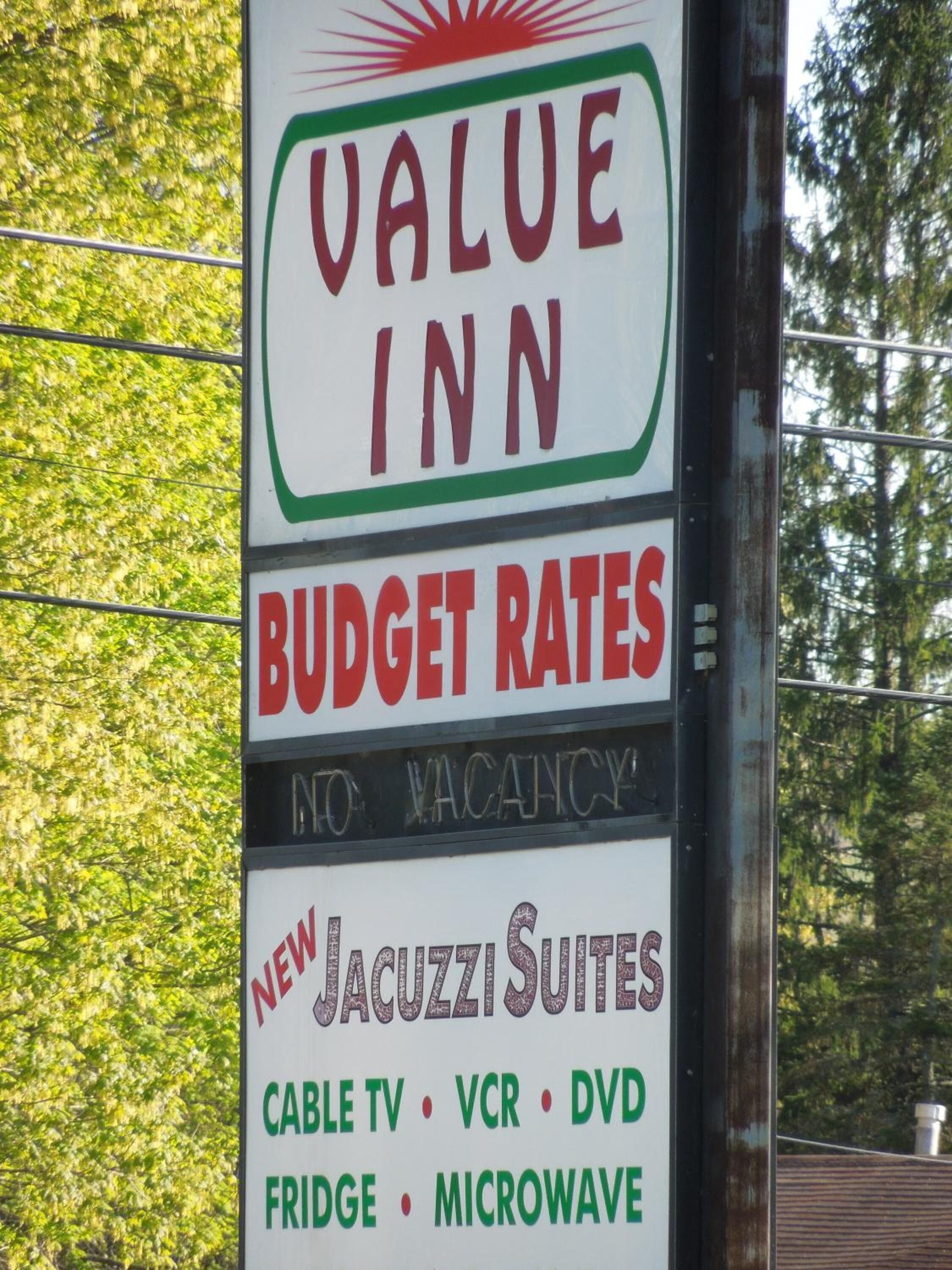 Une enseigne indiquant les tarifs avantageux de l’hôtel Value Inn, l’absence de chambres disponibles et la présence de nouvelles suites avec jacuzzi, équipées de télévision par câble, d’un lecteur vidéo, d’un lecteur DVD, d’un réfrigérateur et d’un four à micro-ondes.
