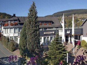 A building with a sign reading "Hotel zur Sonne" and a flagpole with a flag. - Landgasthof Haus zur Sonne (Hallenberg)