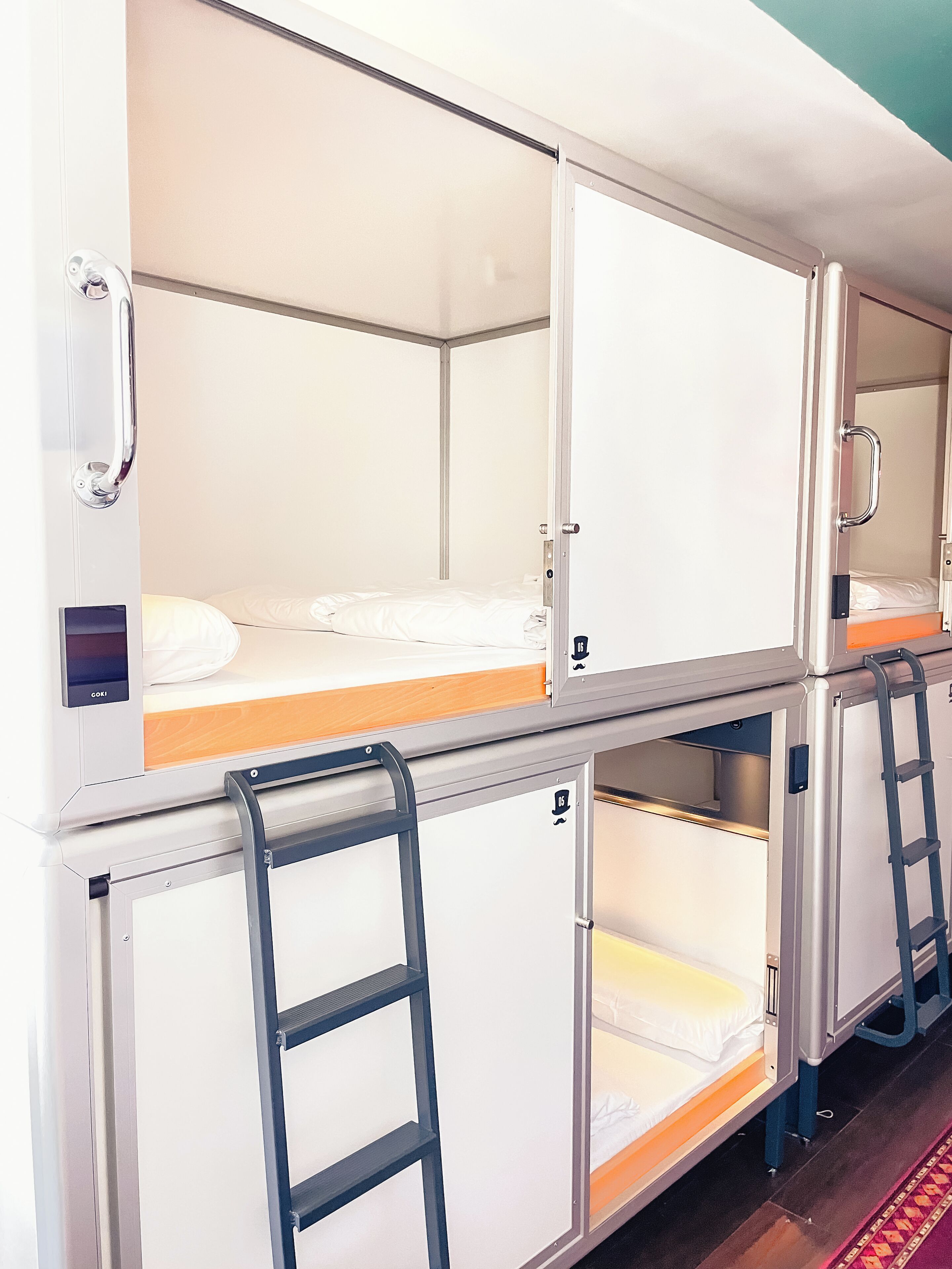 A row of bunk beds with metal railings and a control panel on the left side.