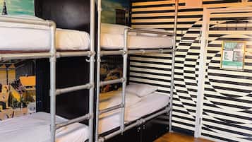 A bunk bed room with a mural, a 'Welcome' sign, and a 'Free' service notice.
