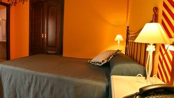 A hotel room with a bed, bedside table, lamp, and a telephone.