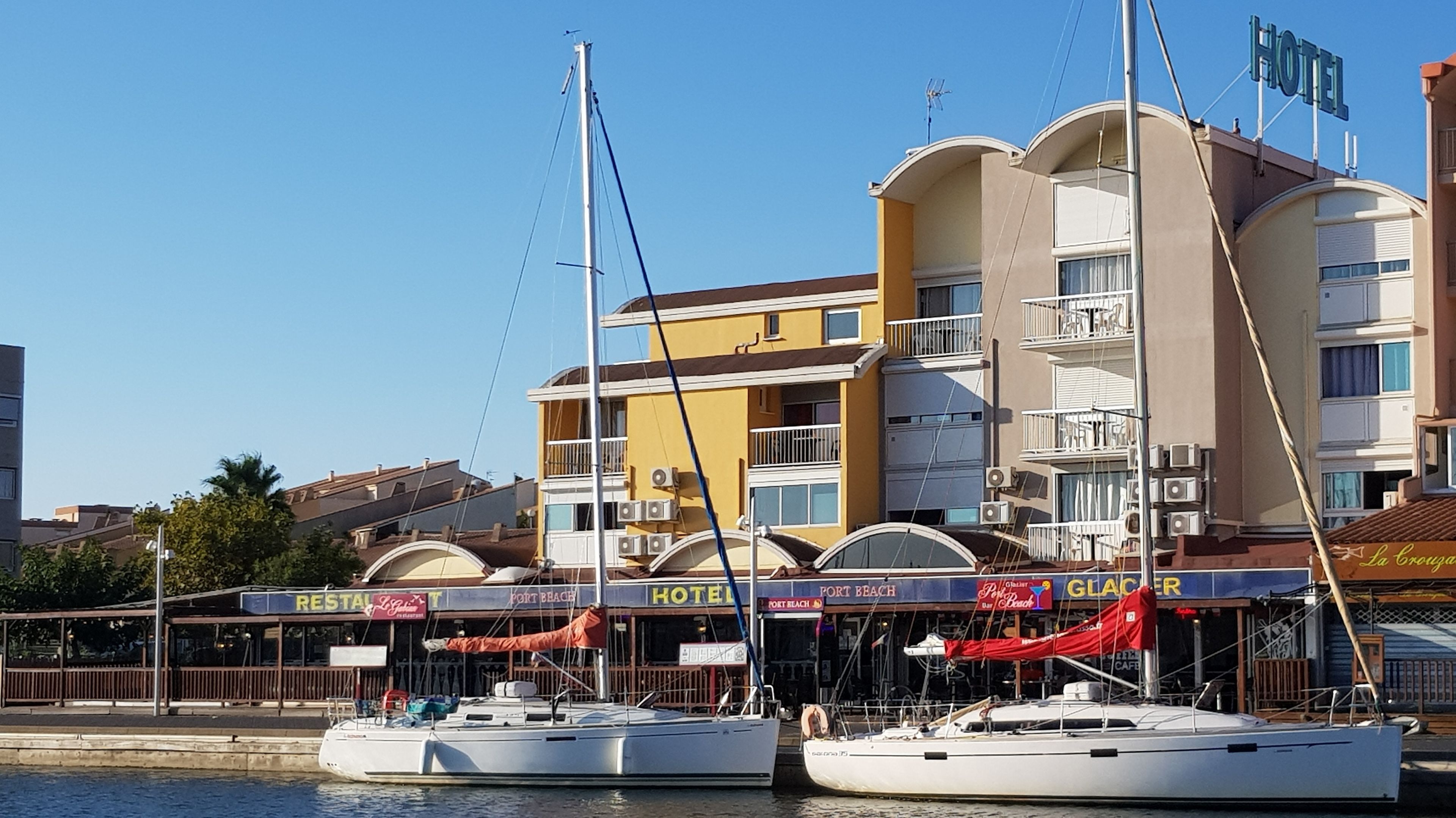 A waterfront hotel with multiple balconies, a restaurant, and a bar.