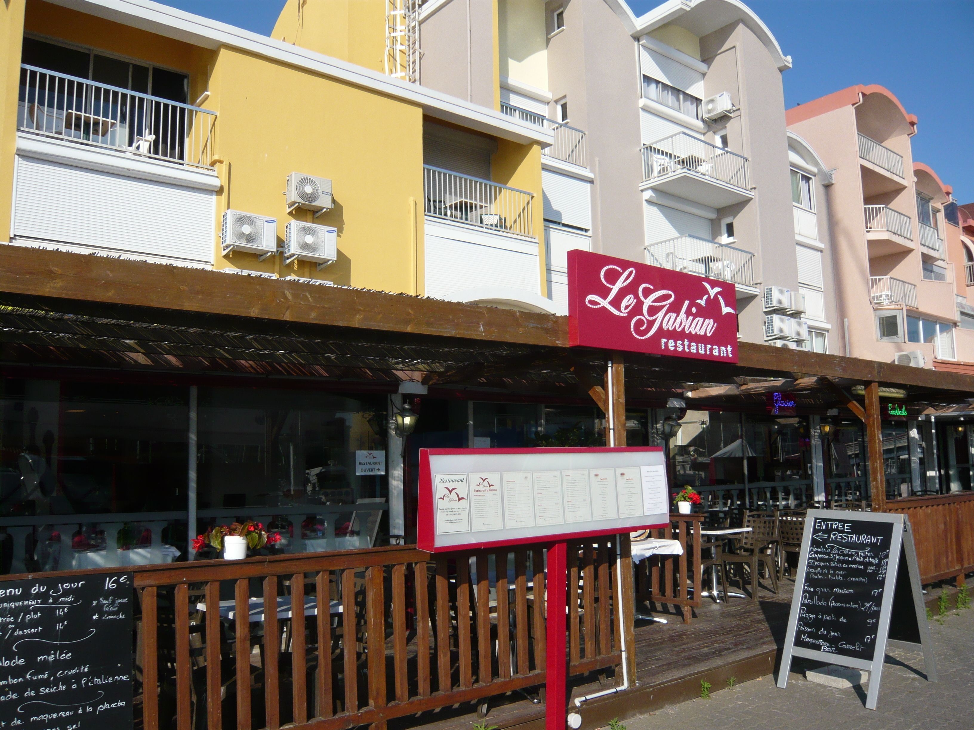 A restaurant named "Le Gabian" with outdoor seating and a menu board.