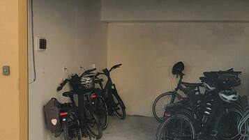 A parking garage with bicycles and helmets.