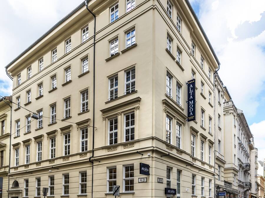 Ein mehrstöckiges Gebäude im klassischen Stil, mit einer auffälligen Schrifttafel für 'Altamoda' an der Fassade.