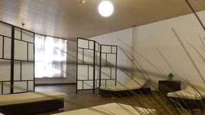 A room with a wooden ceiling, a large window, a sliding partition, and a bed. - Hotel Am Kurpark Späth (Bad Windsheim)