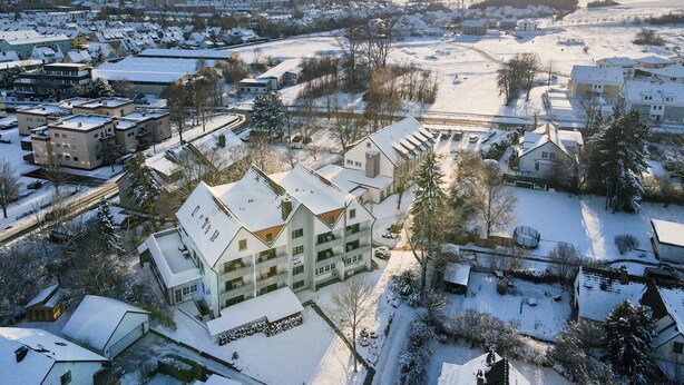 A hotel with multiple floors, a central courtyard, and a view of the surrounding snowy landscape. - Hotel Am Kurpark Späth (Bad Windsheim)