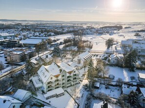A hotel with multiple floors, a central courtyard, and a view of the surrounding snowy landscape. - Hotel Am Kurpark Späth (Bad Windsheim)
