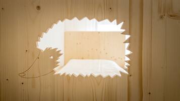 A wooden panel with a cut-out shape, possibly for a window or decorative element.