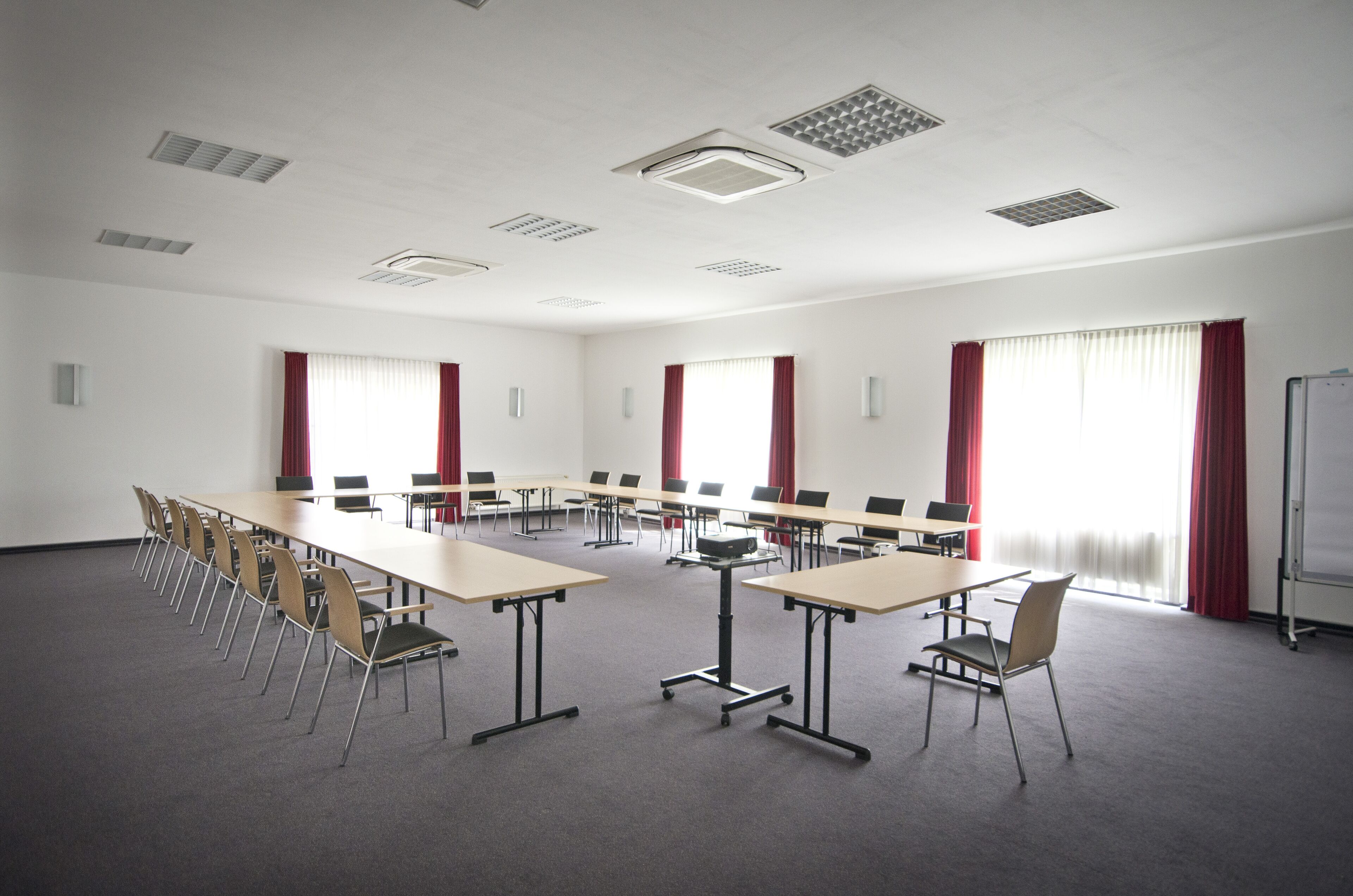 A conference room with a long table, chairs, and a whiteboard.