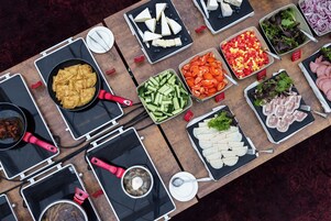 Una mesa de buffet con diversos alimentos y utensilios de cocina.