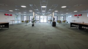 A spacious conference room with a high ceiling, large windows, and a carpeted floor. - Milling Hotel Park (Middelfart)