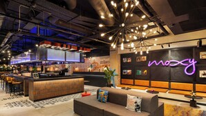 Un espace bar moderne avec un panneau néon, un canapé et un comptoir.