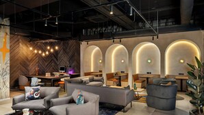Un hall d’entrée moderne avec des canapés, une table basse et un comptoir d’accueil.