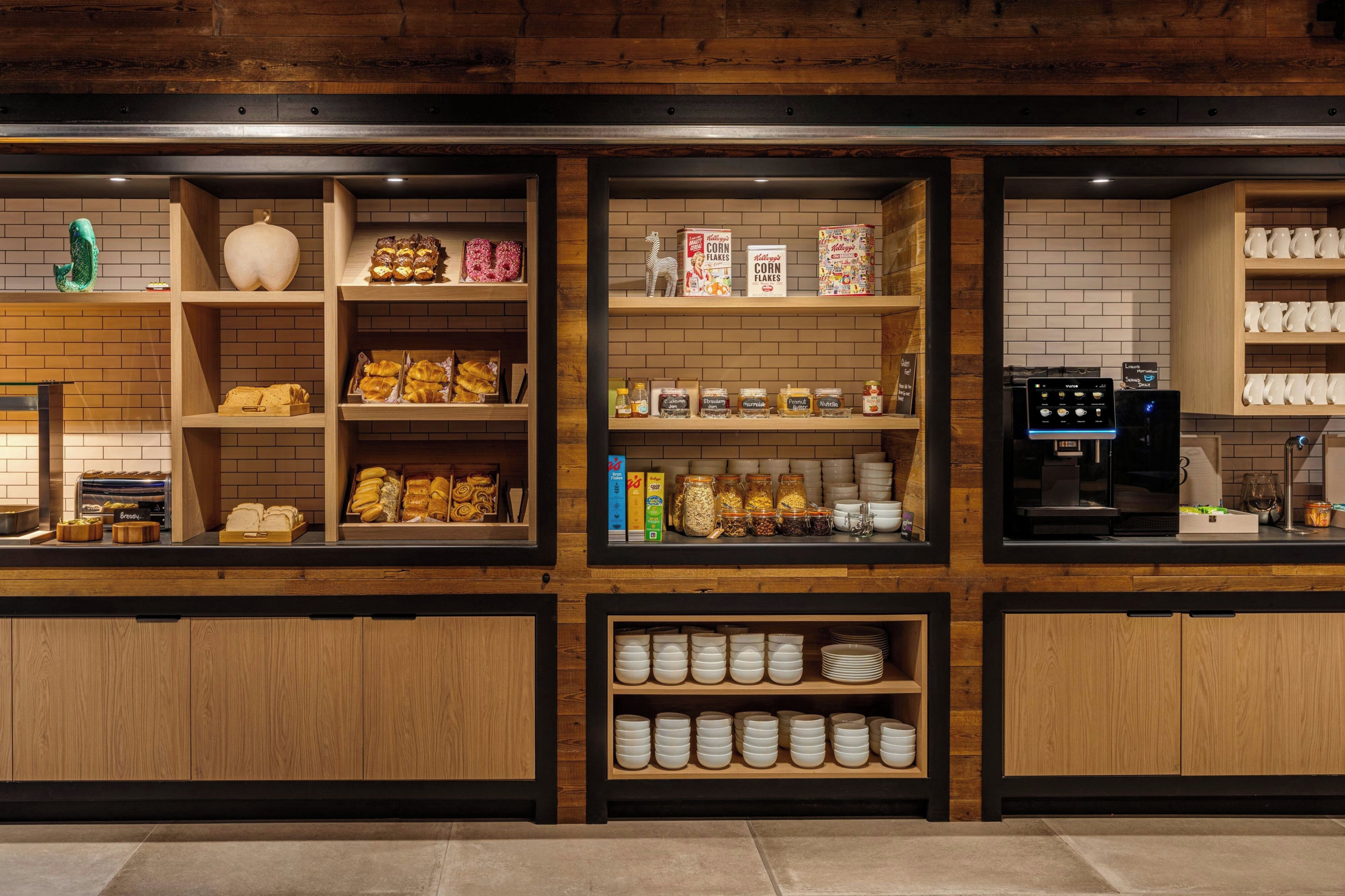 A bakery counter with various baked goods, jars of spreads, and a coffee machine.