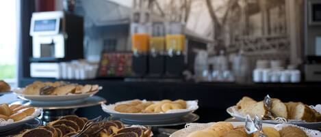 A buffet table with various pastries and bread.