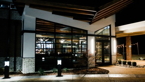 A modern building with large glass windows and a brick facade. - The Lodge at Kiln Creek Resort (Newport News)