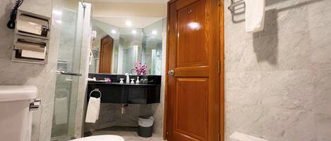 Un baño con inodoro, lavamanos, espejo, ducha y bañera.