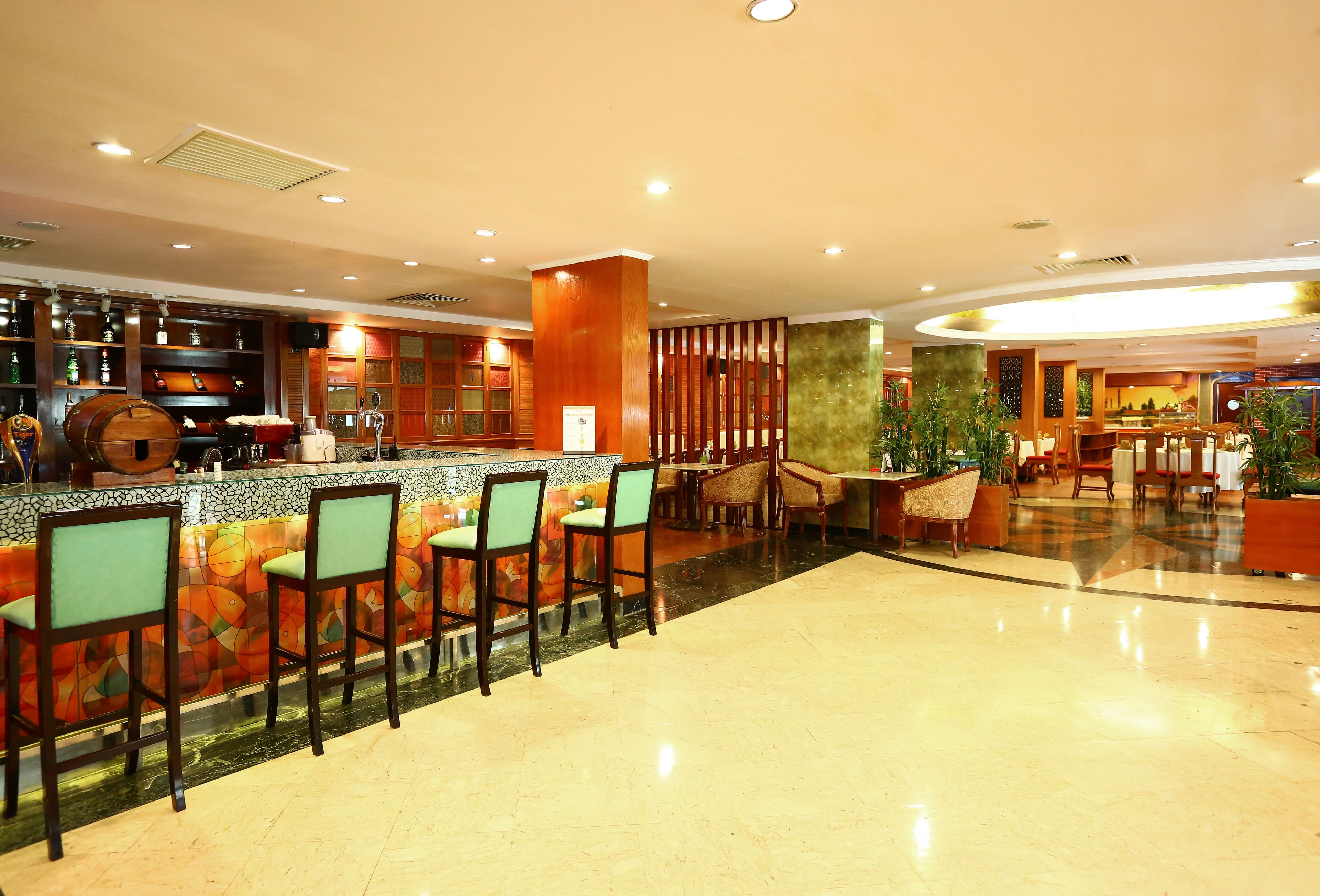 A bar area with a counter, stools, and a decorative wall.