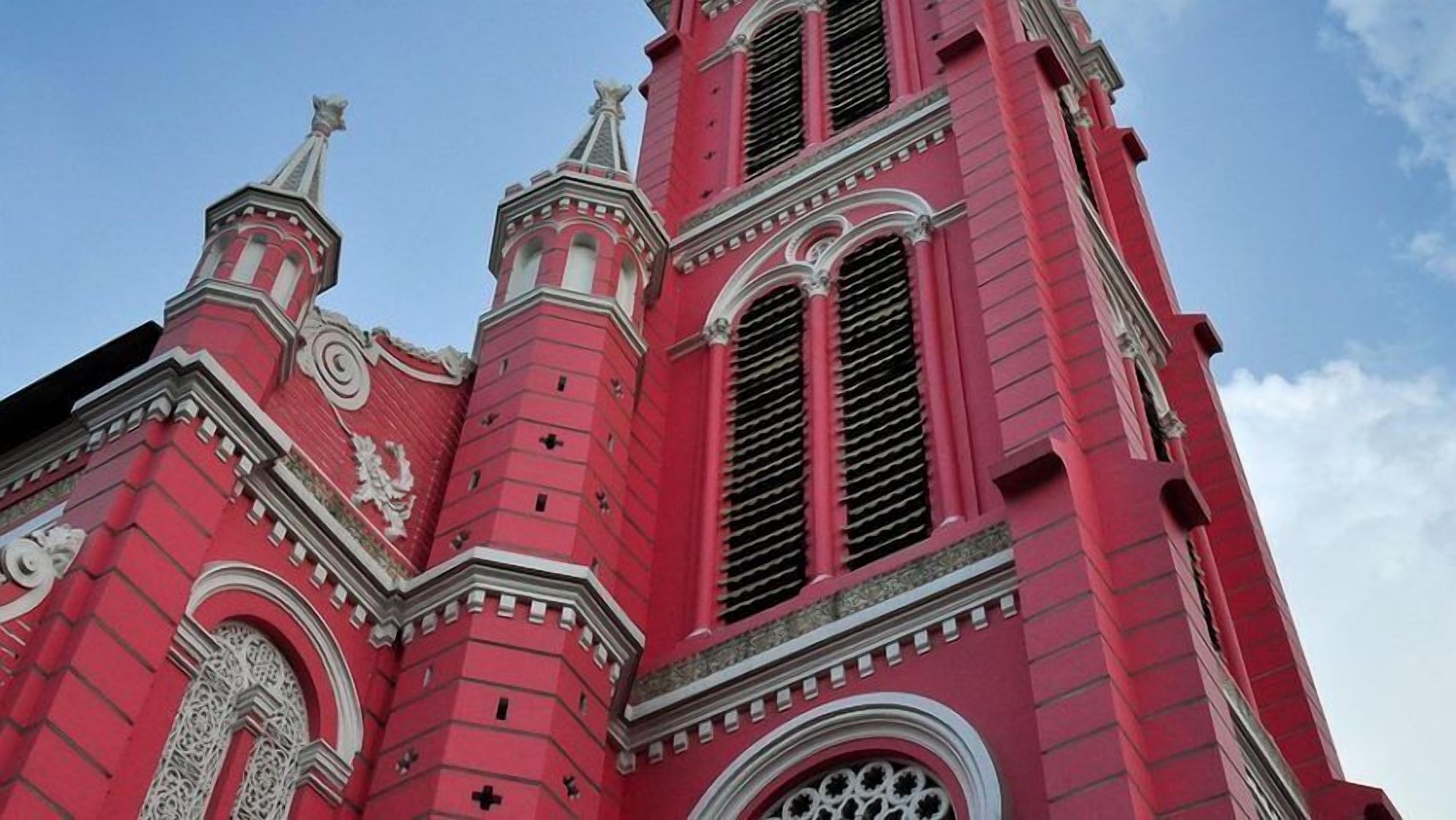 A red church with ornate architectural details and a clear sky.