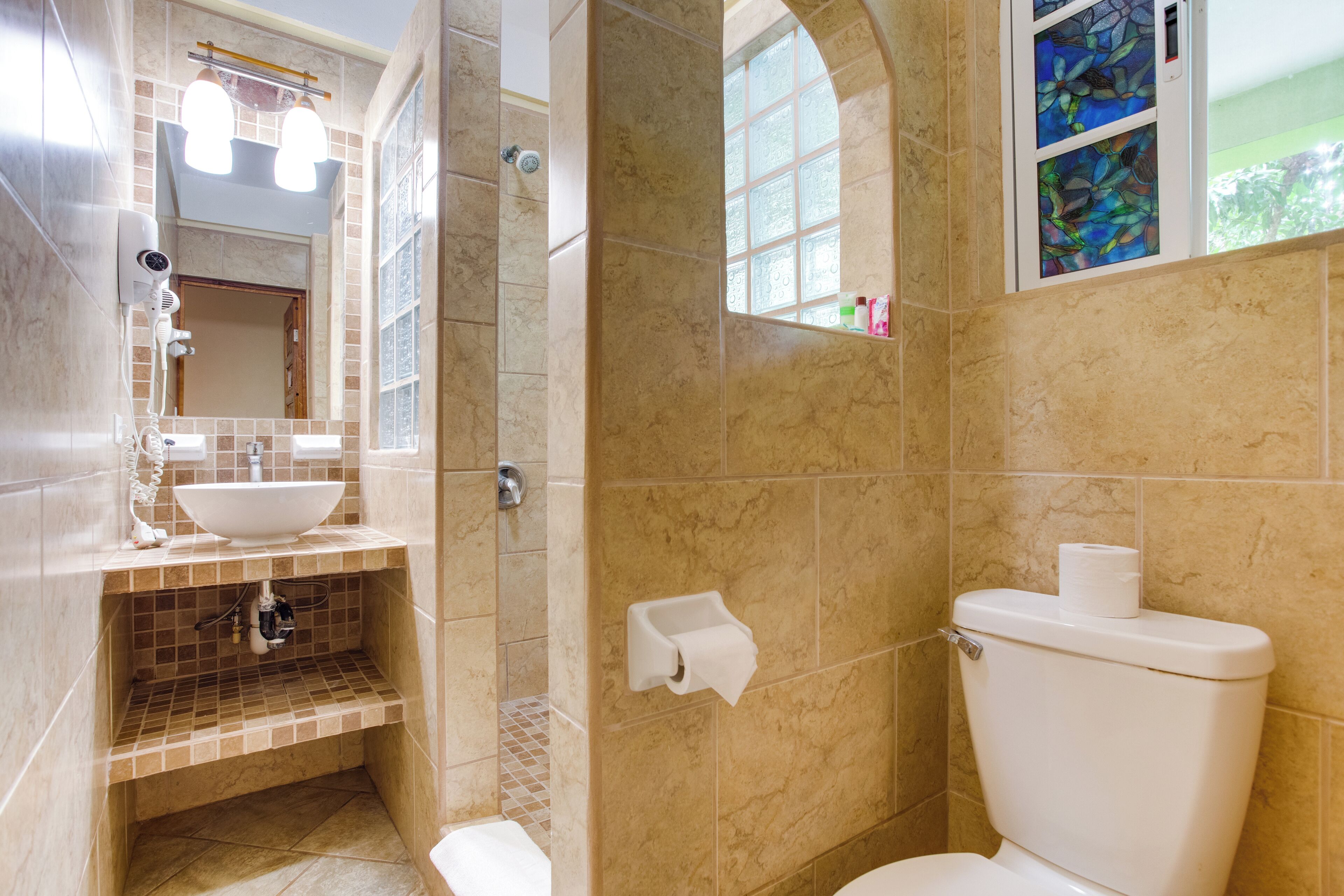 Un baño con lavamanos blanco, inodoro y zona de ducha.