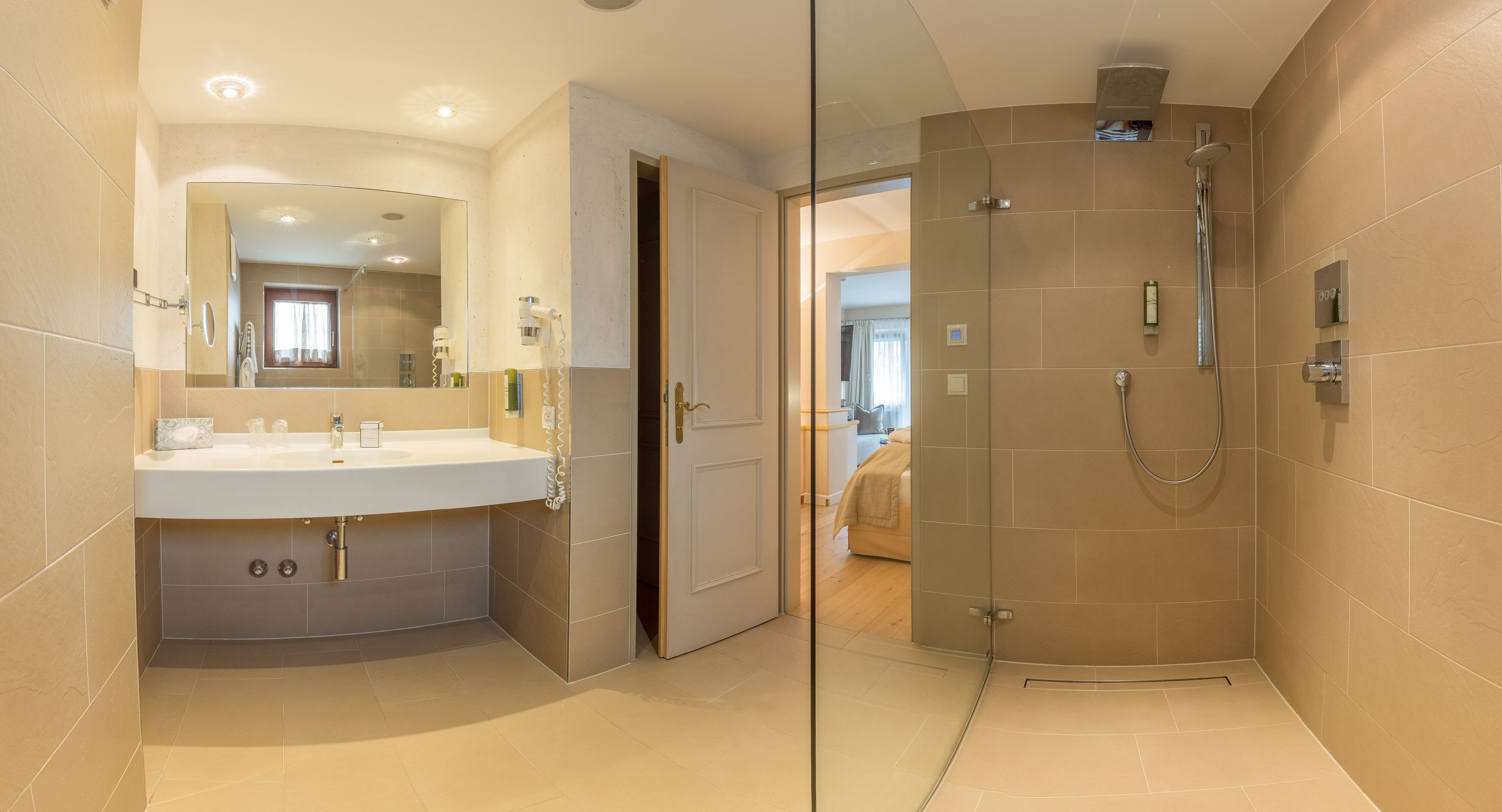 Een moderne badkamer met een douchecabine van glas, een wastafelmeubel en een spiegel.