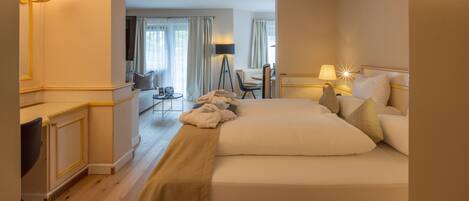 A hotel room with a large bed, bedside tables, a desk, and a chair.