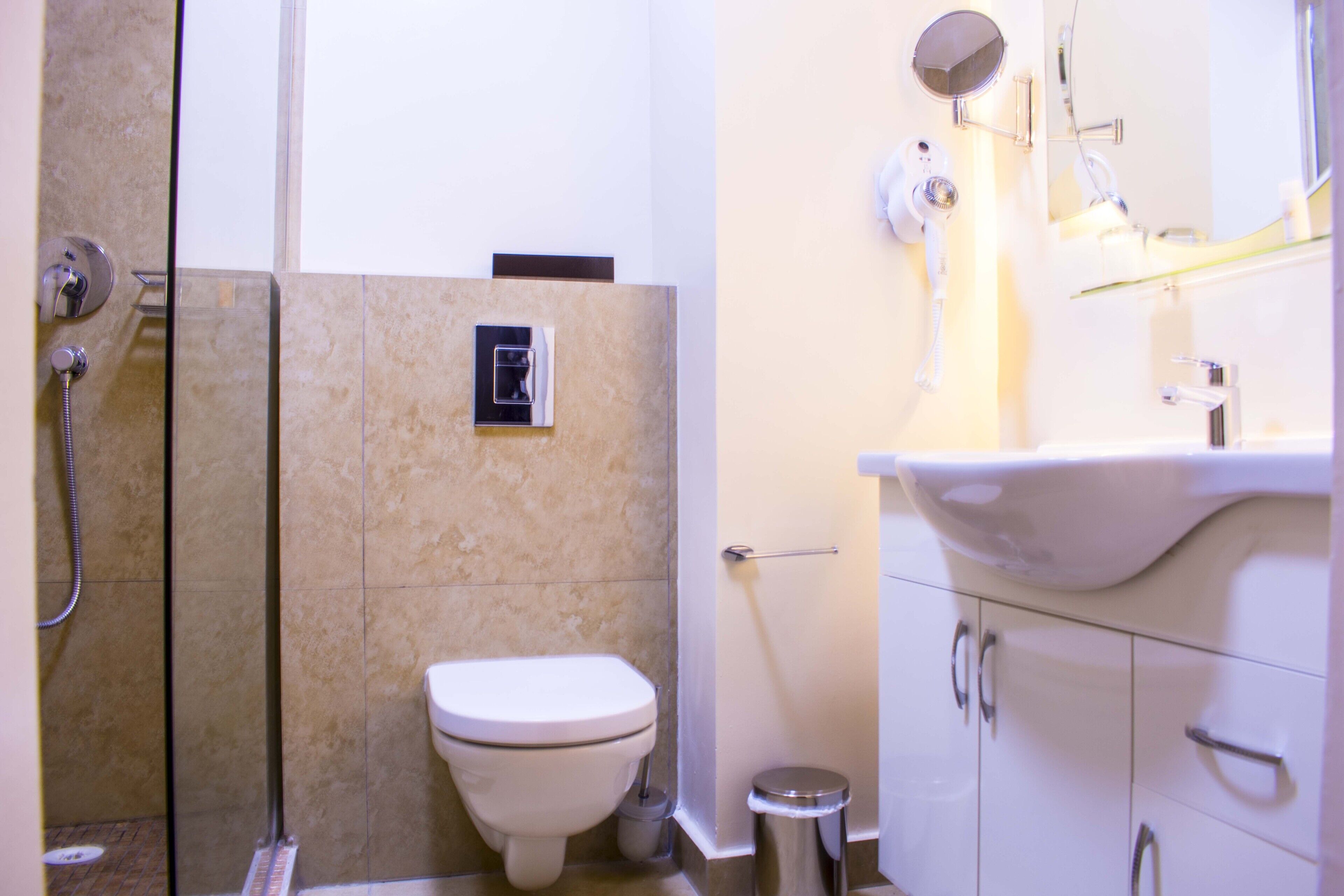 Une salle de bain avec des toilettes, une douche et un lavabo.