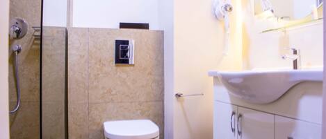 Une salle de bain avec des toilettes, une douche et un lavabo.