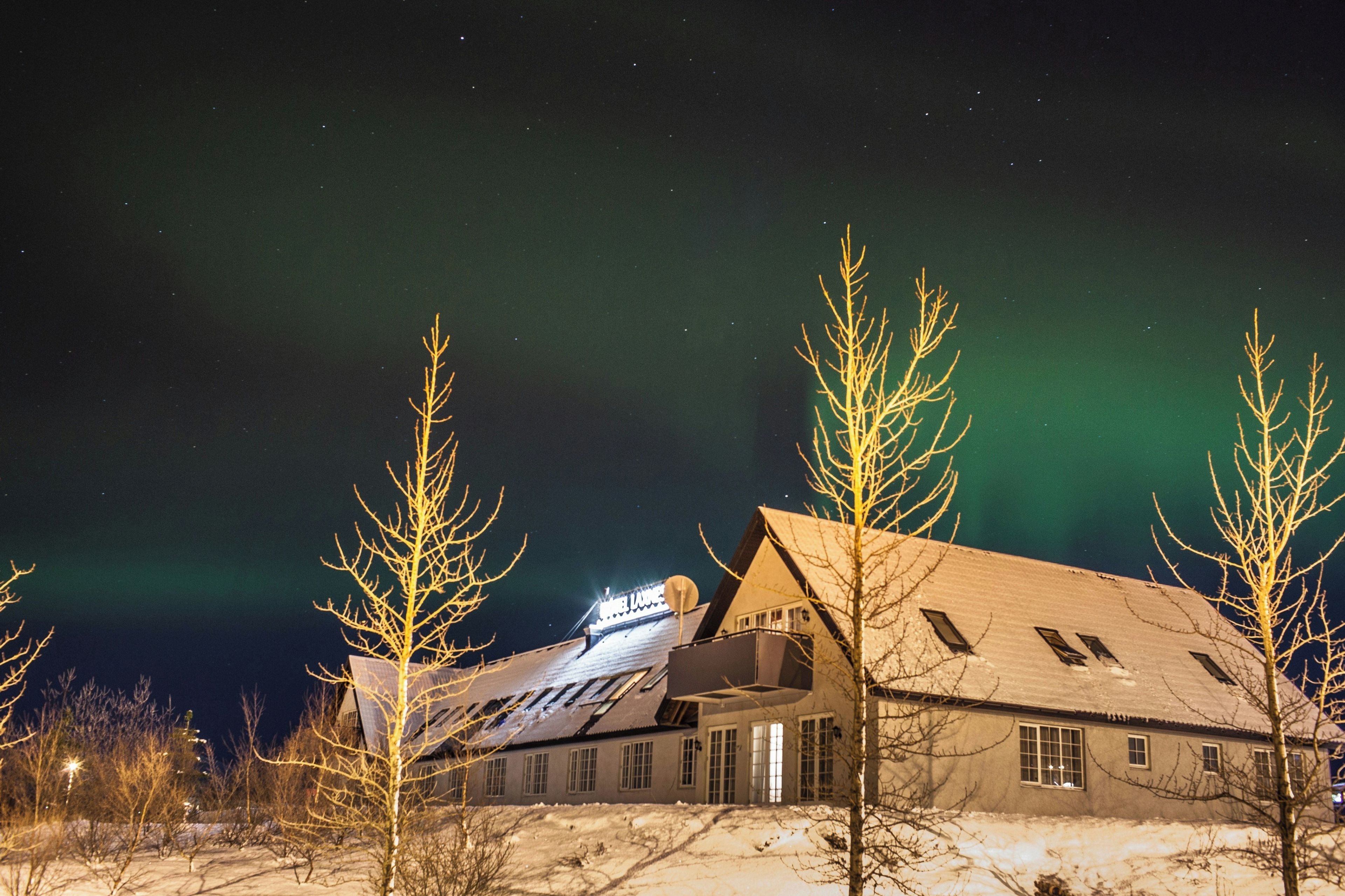 A building with a sloped roof, multiple windows, and a snow-covered ground.