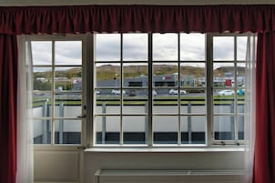 A window with a view of a parking lot and a KFC restaurant.