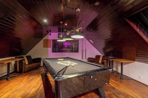 A billiards room with a pool table, leather seating, and pendant lighting. - Hotel Laxnes (Mosfellsbær)