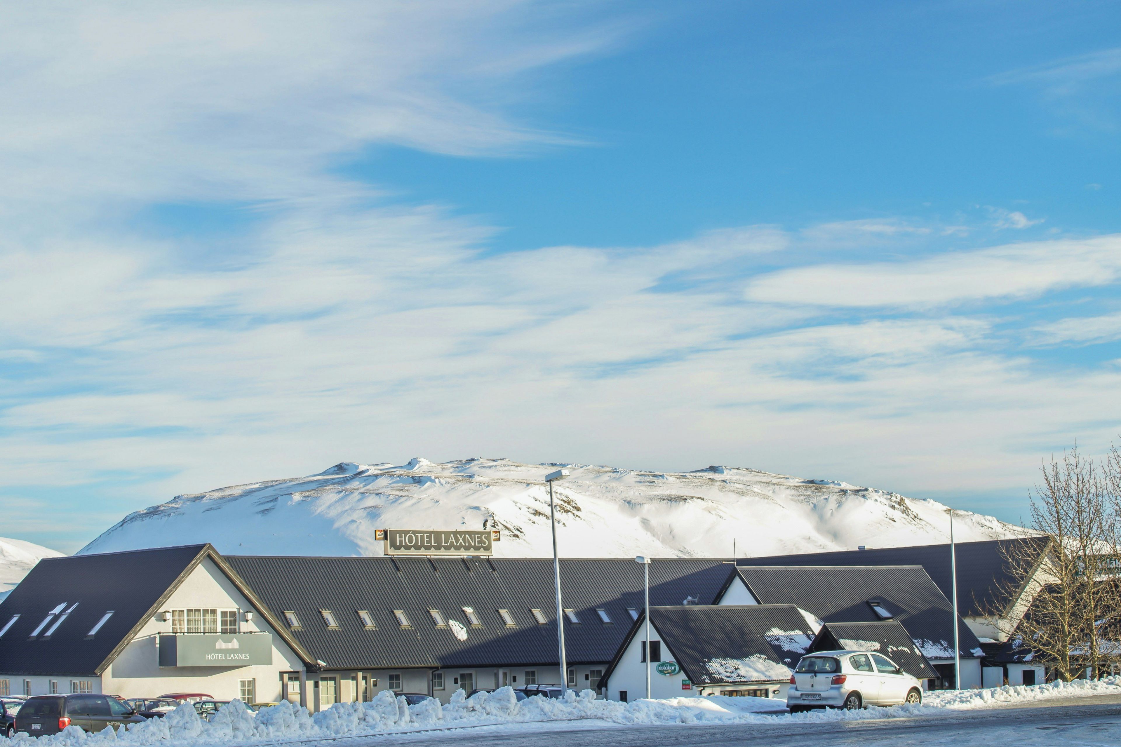 Un hotel con un letrero que dice 'Hôtel Laxnes' frente a una montaña nevada.