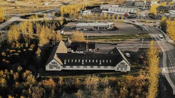 A large, two-story building with a flat roof, surrounded by trees and a parking lot.