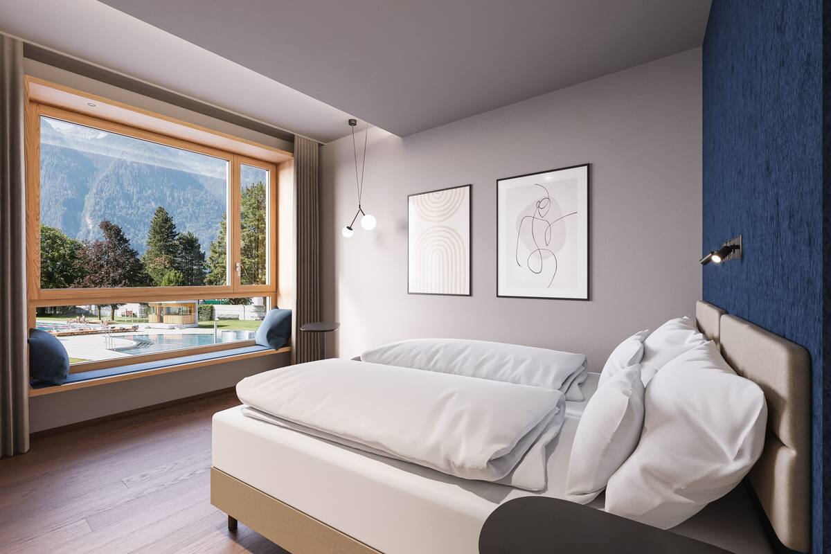 A modern bedroom with a large window, a bed, and two framed artworks on the wall.