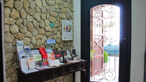 Un mostrador de recepción con folletos y una pared de piedra.