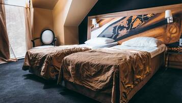 Una habitación de hotel con dos camas, un espejo grande y un cabecero con un panel decorativo.