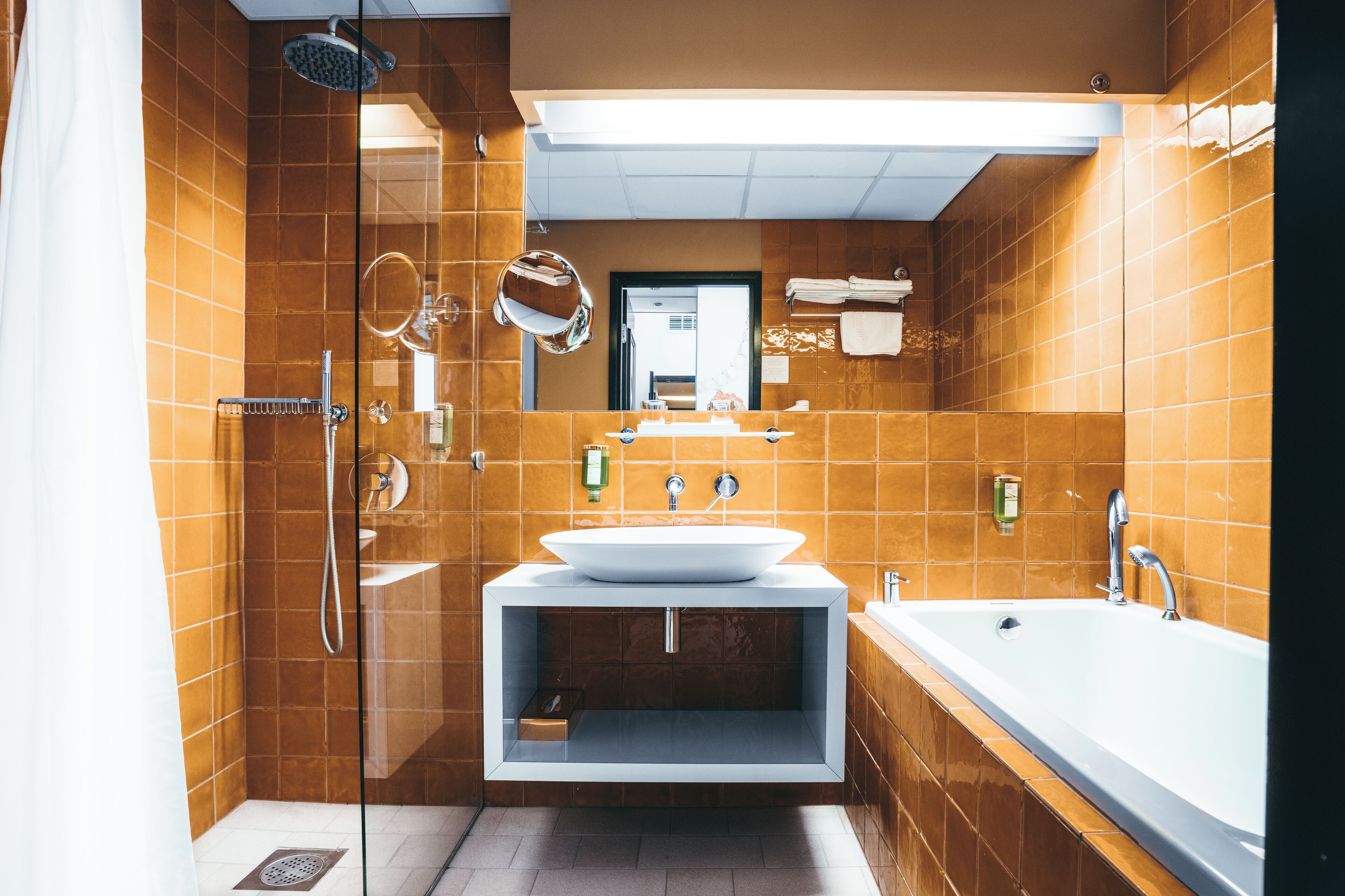 Un baño moderno con ducha de vidrio, un lavamanos grande y una bañera.