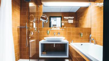 Un baño moderno con ducha de vidrio, un lavamanos grande y una bañera.