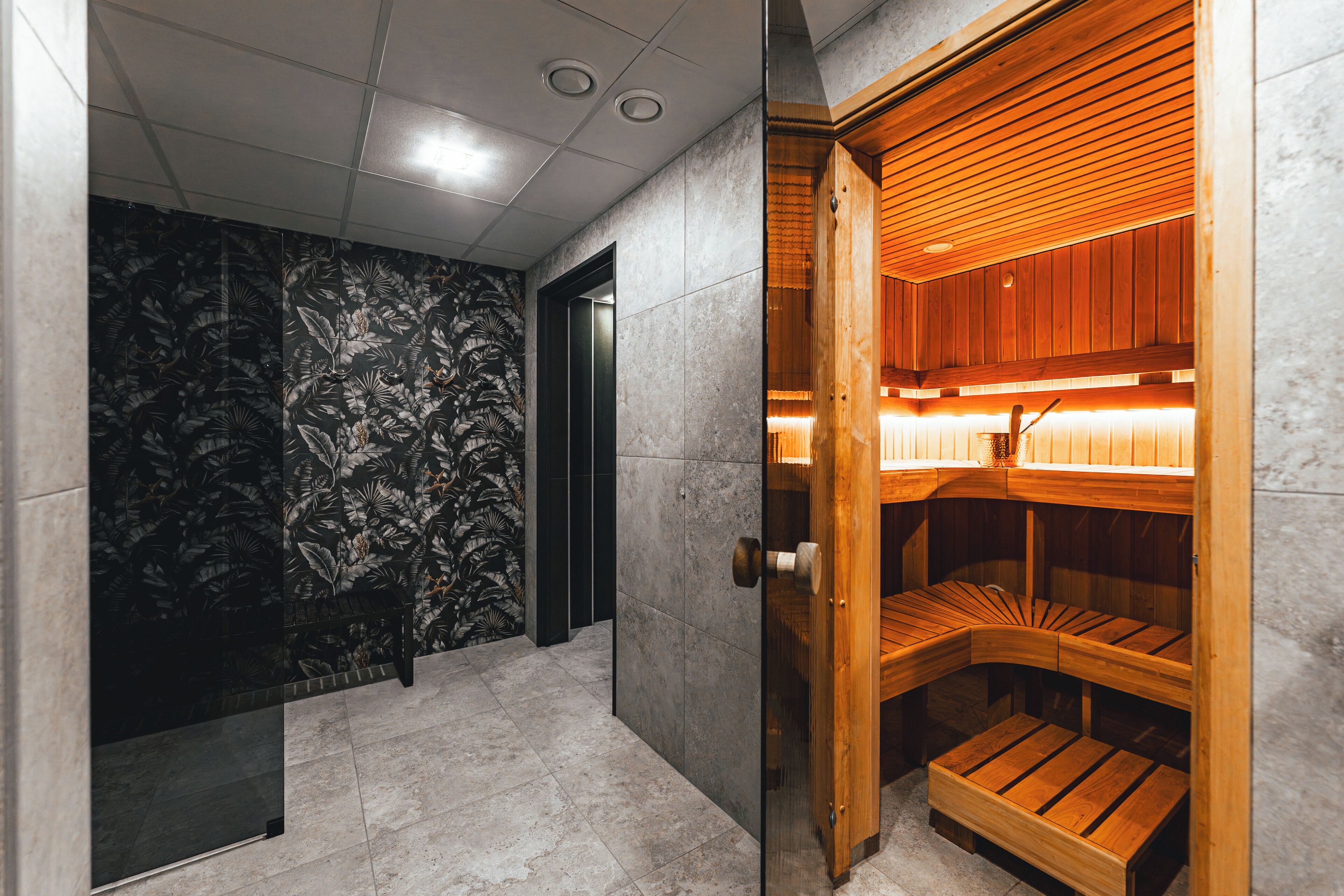A sauna room with a wooden bench and a tiled floor.